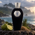 V Canto Alibi on volcanic stone beside bergamot, cypress, and vetiver roots, with a misty tropical coast in warm side light.