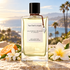 Van Cleef & Arpels California Reverie with white blossoms and mandarin on a sunlit terrace overlooking a palm-lined coast.