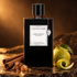 Van Cleef & Arpels Ambre Impérial on dark stone with cinnamon bark, golden resin, and bergamot in warm amber light.
