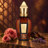 Xerjoff Alexandria III’s patterned bottle beside pink roses, oud wood, and lavender on warm dark stone, with soft geometric shadows behind it.