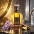 Xerjoff Aqua Regia on dark stone beside a violet iris, cedarwood, and bergamot, illuminated by warm gold and cool silver light.