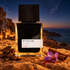 MiN New York Dahab bottle beside oud wood, cinnamon and a saffron crocus on sandstone above a desert coast under stars.