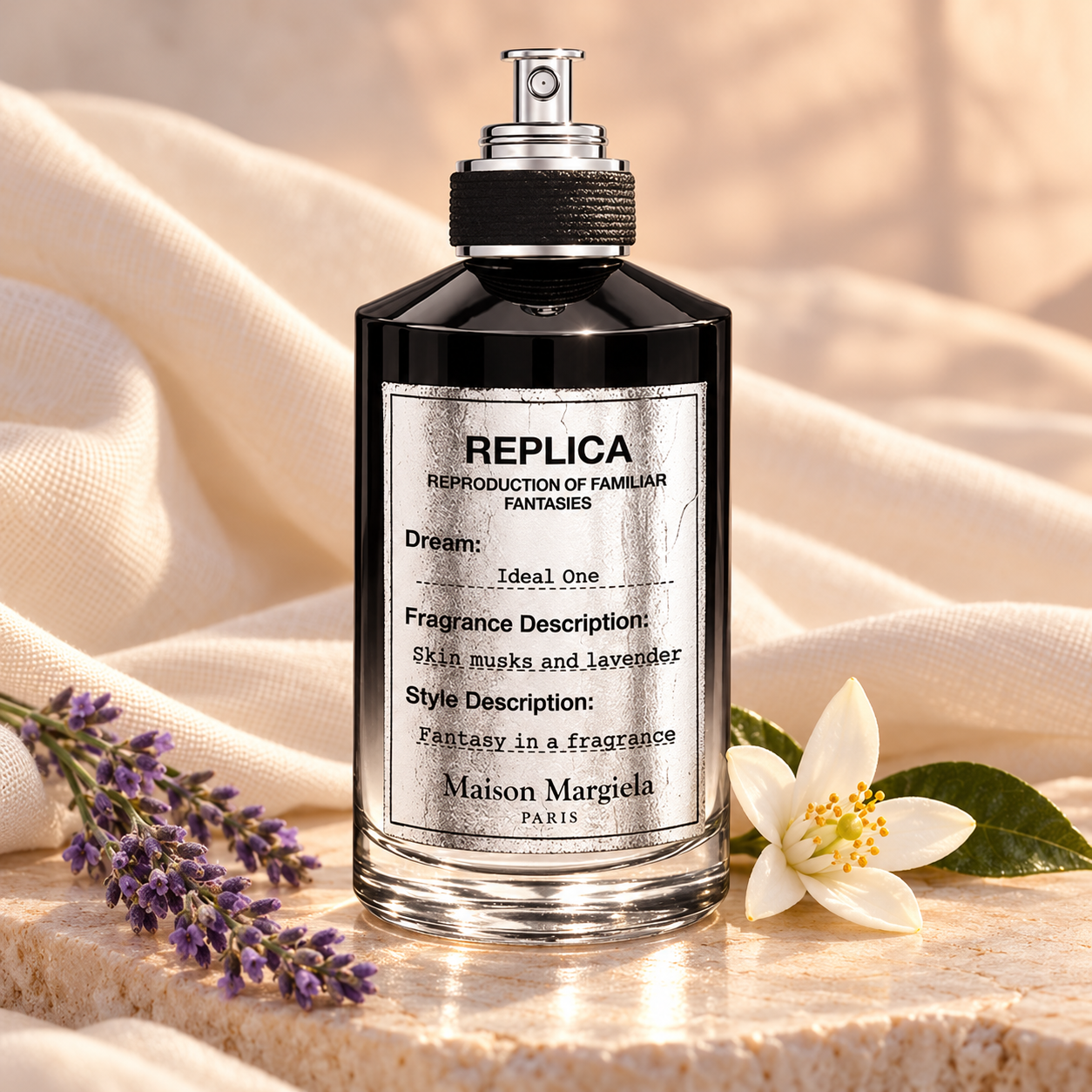 Maison Margiela Replica Ideal One bottle on pale stone beside lavender and orange blossom with softly draped ivory fabric.