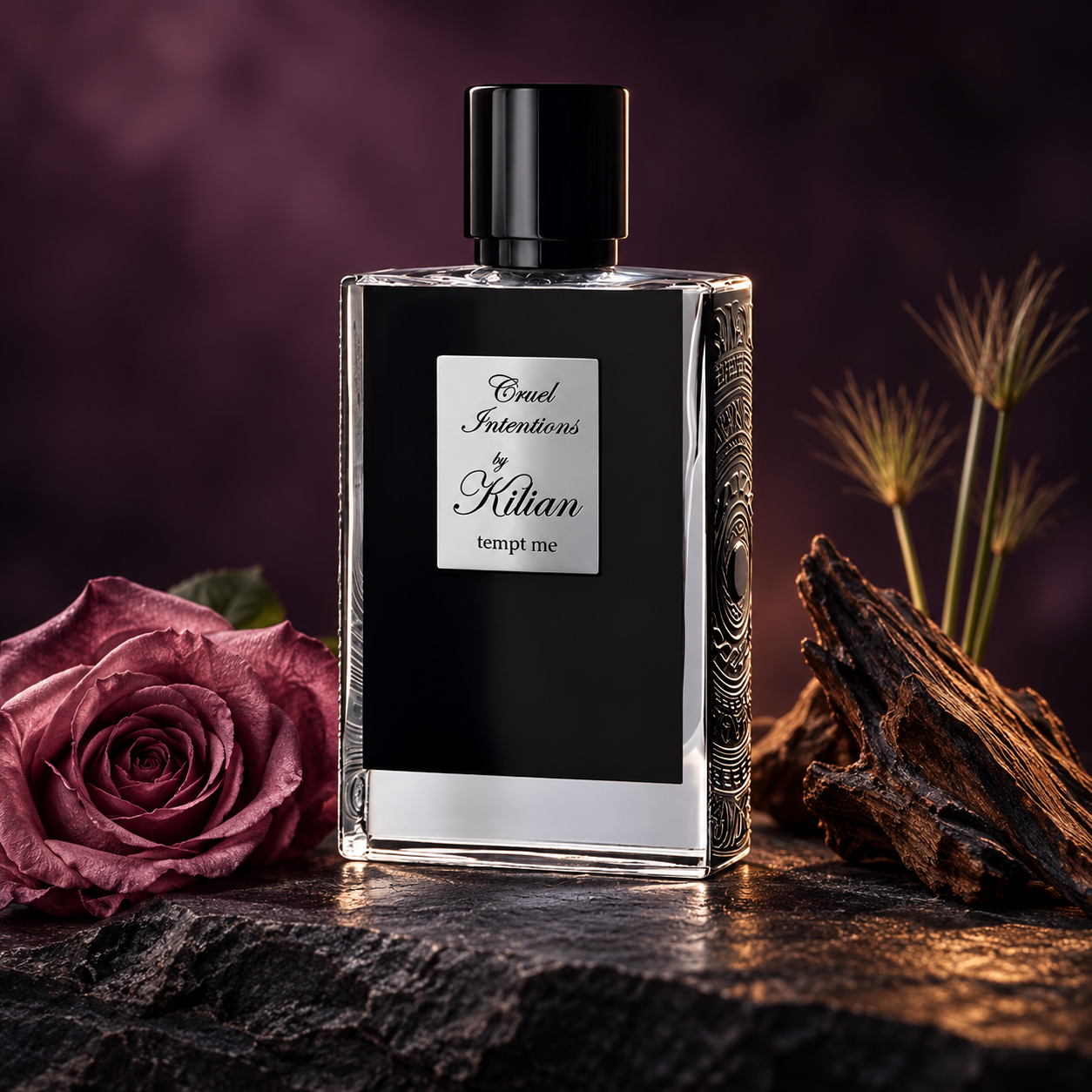 Kilian Cruel Intentions black perfume bottle beside a mauve rose, oud wood and papyrus on dark stone against a plum background.