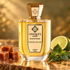 Unique'e Luxury Crush On Me perfume bottle with caramel pieces, patchouli leaves and a lime half in warm golden light.